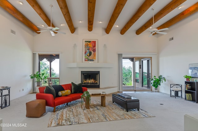 living room featuring a healthy amount of sunlight, beamed ceiling, and a high ceiling