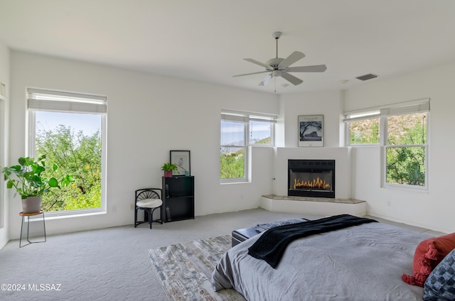 carpeted bedroom with multiple windows and ceiling fan