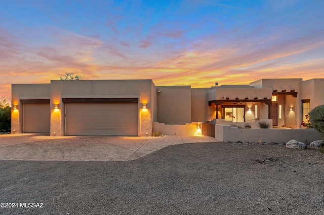 pueblo-style house featuring a garage