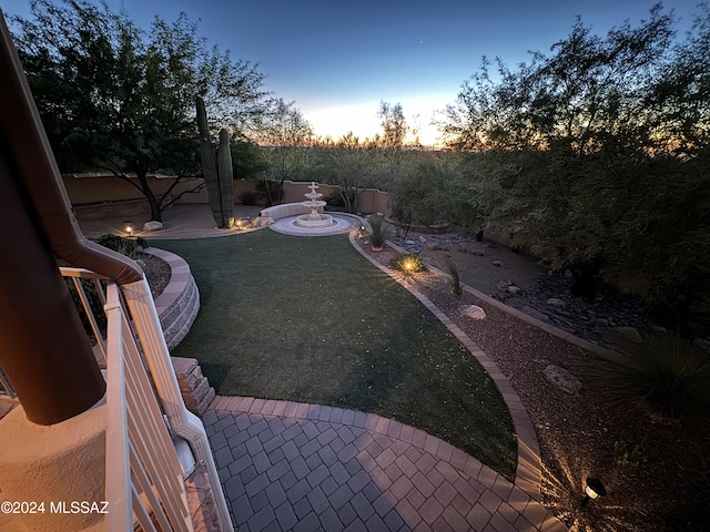 yard at dusk featuring a patio