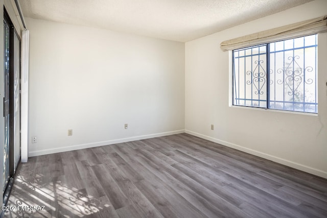 empty room featuring dark wood-type flooring and a textured ceiling