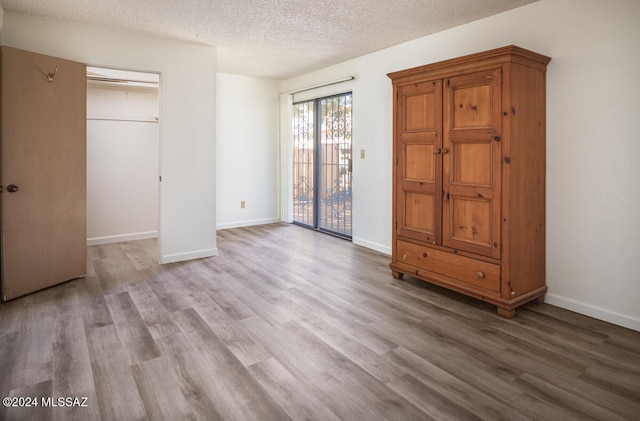 unfurnished bedroom featuring light hardwood / wood-style floors and a textured ceiling