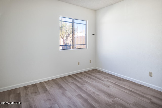 empty room featuring a textured ceiling and light wood-type flooring