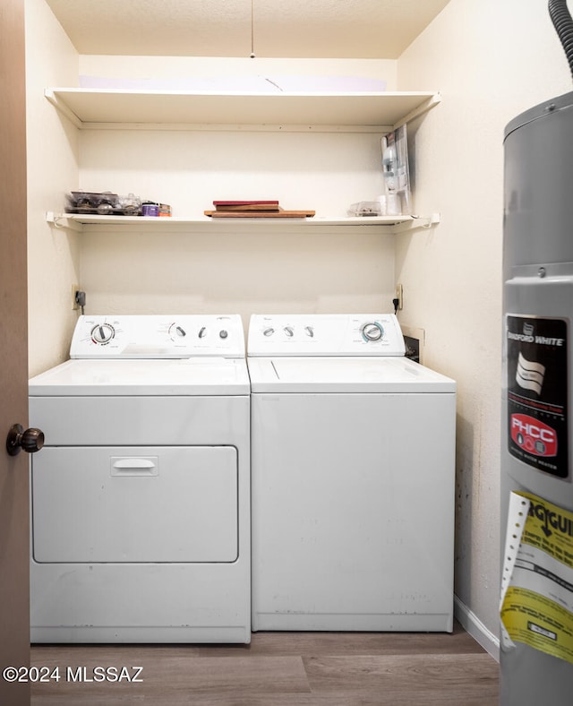 washroom with washer and dryer, wood-type flooring, and water heater