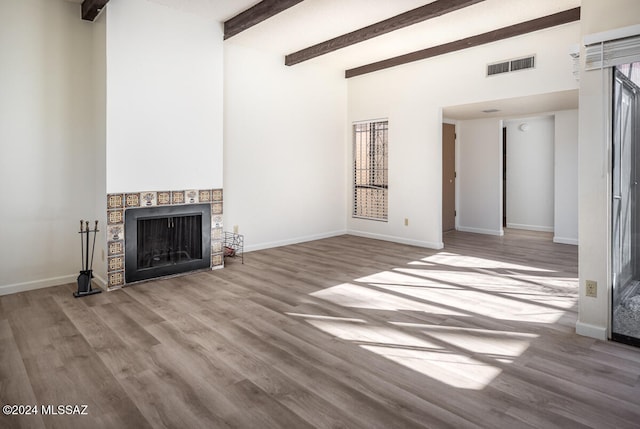 unfurnished living room with beam ceiling and light hardwood / wood-style flooring