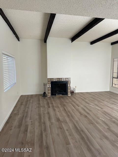 unfurnished living room featuring a textured ceiling, a healthy amount of sunlight, and hardwood / wood-style flooring