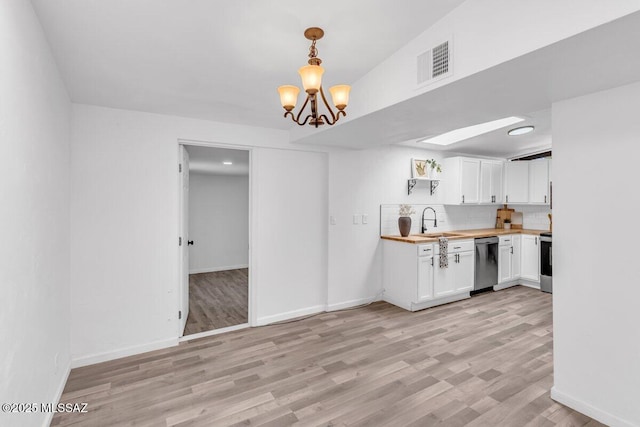 kitchen with visible vents, white cabinets, appliances with stainless steel finishes, wooden counters, and a sink