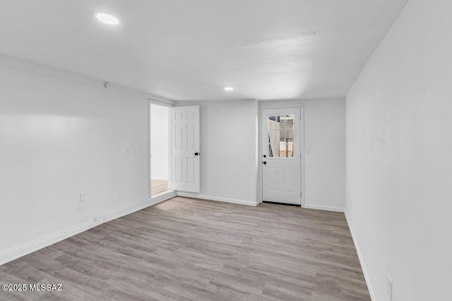 empty room with recessed lighting, wood finished floors, and baseboards