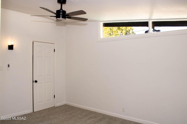 spare room featuring carpet floors, ceiling fan, and baseboards