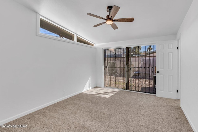 carpeted empty room with ceiling fan, baseboards, and vaulted ceiling