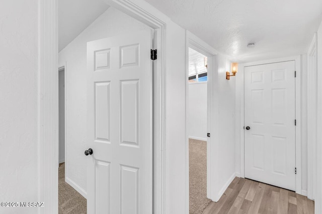 hall featuring light wood-style floors and baseboards