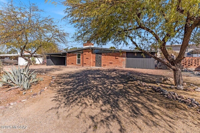 view of front of property with brick siding and a chimney