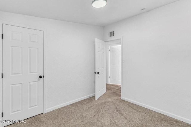 unfurnished bedroom featuring carpet, visible vents, and baseboards