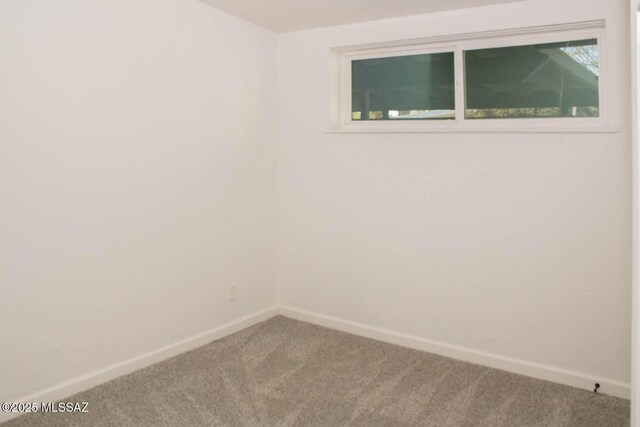 spare room featuring carpet and baseboards