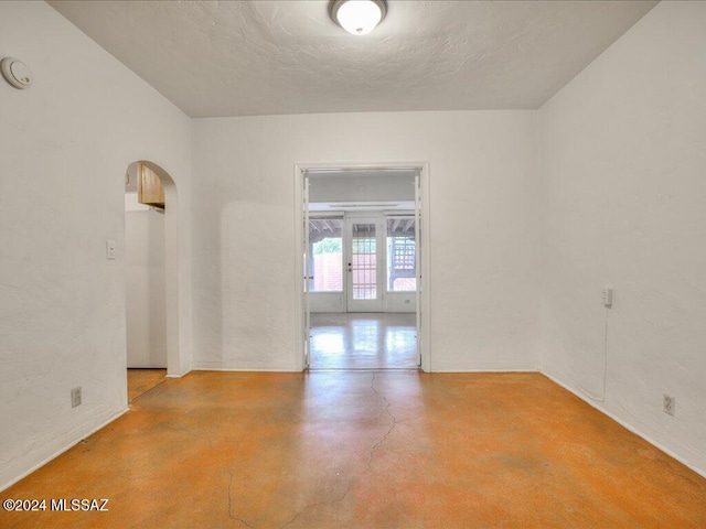 spare room with a textured ceiling and concrete floors