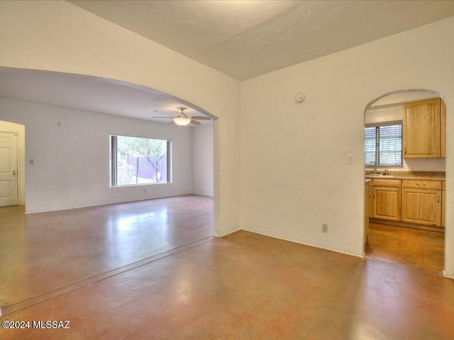 spare room featuring a wealth of natural light, ceiling fan, and sink