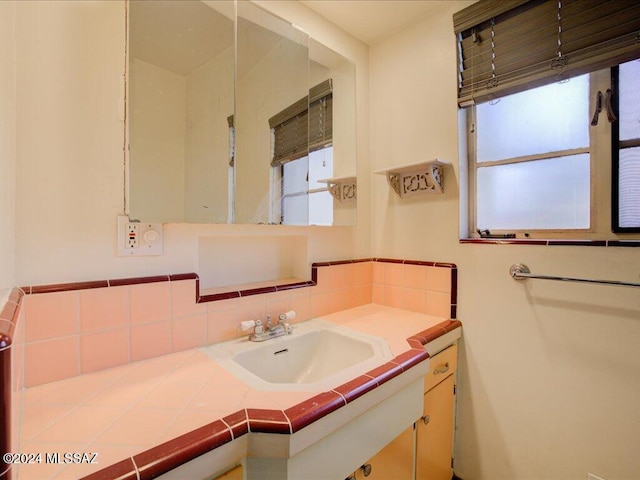 bathroom with vanity and tasteful backsplash