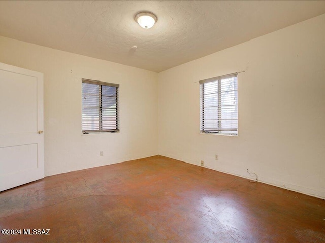 unfurnished room featuring concrete flooring and a textured ceiling