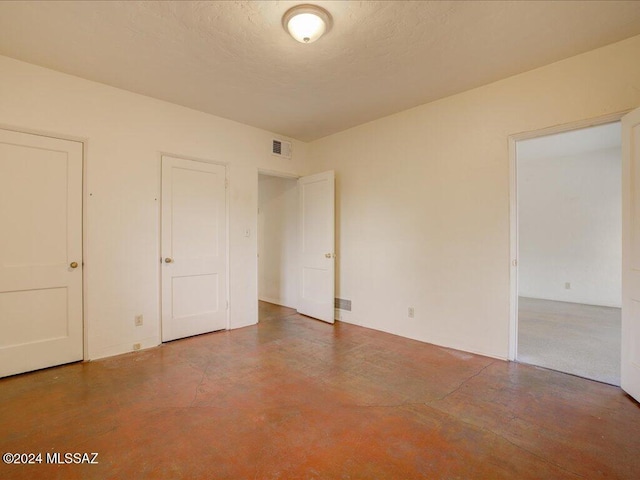 unfurnished room with concrete floors and a textured ceiling