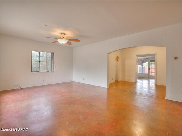 unfurnished room with concrete flooring, ceiling fan, and plenty of natural light