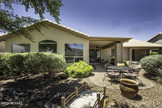 rear view of property featuring ceiling fan and a patio