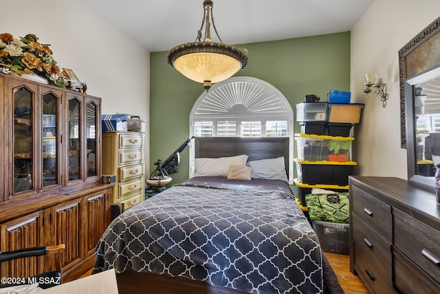 bedroom with multiple windows and hardwood / wood-style flooring