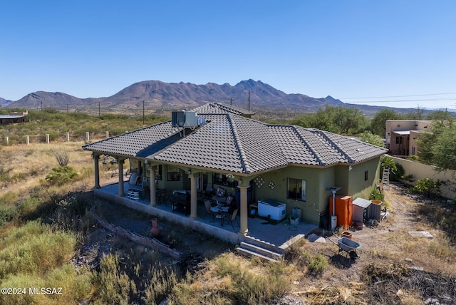 rear view of house with central AC and a mountain view