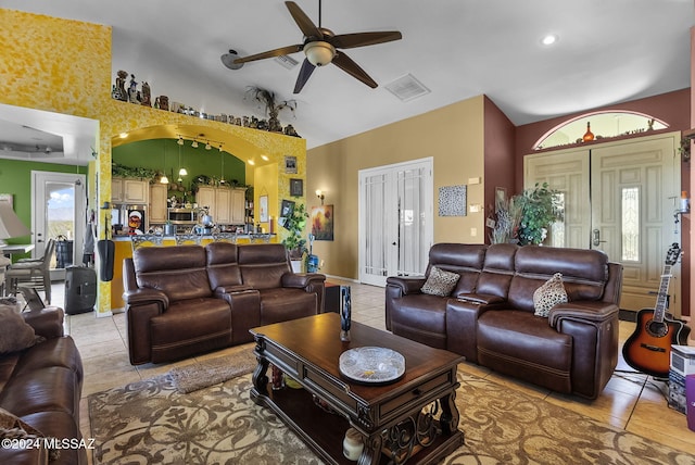 living room with ceiling fan, lofted ceiling, and light tile patterned floors