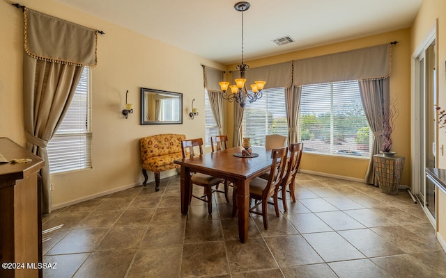 tiled dining room with an inviting chandelier