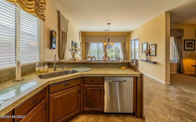 kitchen with hanging light fixtures, sink, light tile patterned flooring, stainless steel dishwasher, and a chandelier