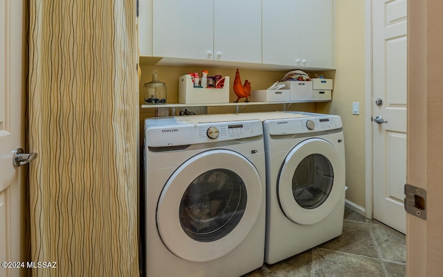 clothes washing area with cabinets and separate washer and dryer