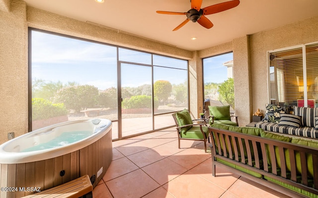 sunroom / solarium featuring ceiling fan and a jacuzzi