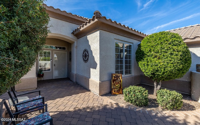 view of exterior entry featuring a patio area