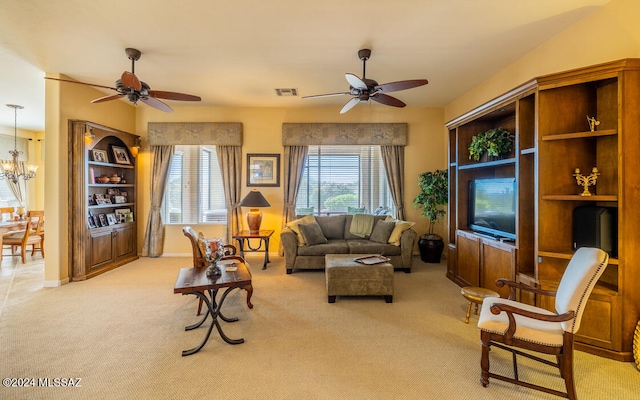 carpeted living room featuring ceiling fan with notable chandelier