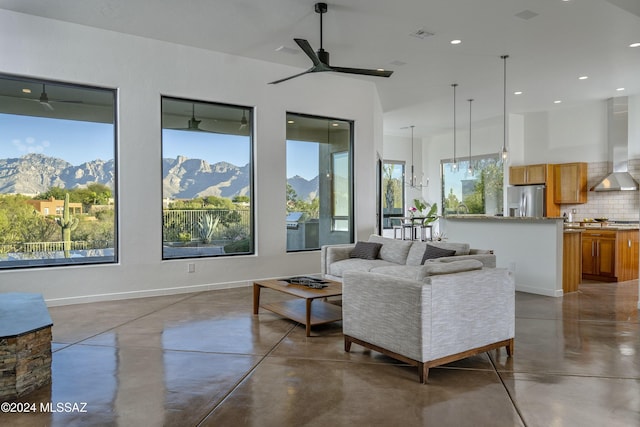 living room with a mountain view, concrete floors, and ceiling fan