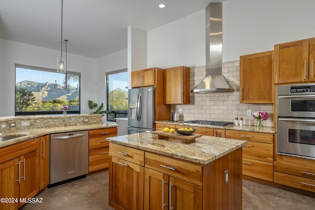 kitchen with wall chimney exhaust hood, tasteful backsplash, a kitchen island, pendant lighting, and stainless steel appliances