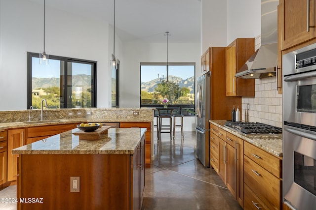 kitchen featuring pendant lighting, a mountain view, wall chimney range hood, and a kitchen island