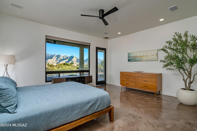 bedroom with ceiling fan, a mountain view, concrete floors, and access to outside