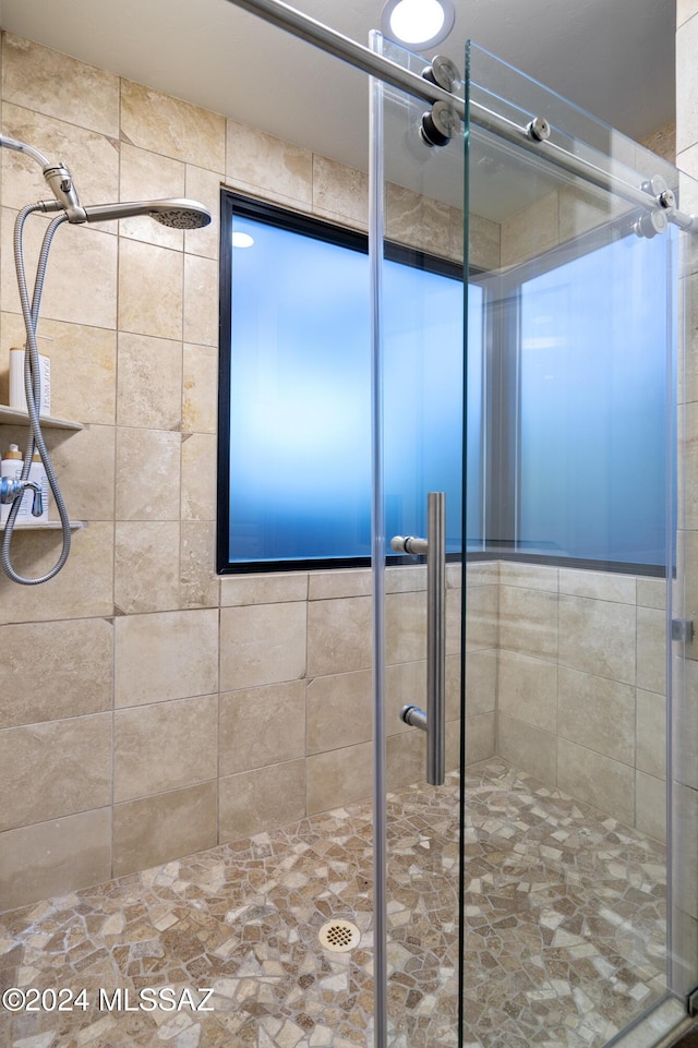 bathroom featuring a shower with door