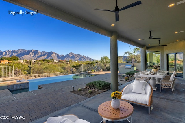 view of patio / terrace with a fenced in pool, a mountain view, area for grilling, and ceiling fan