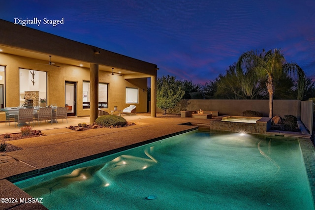 pool at dusk with an in ground hot tub, ceiling fan, and a patio