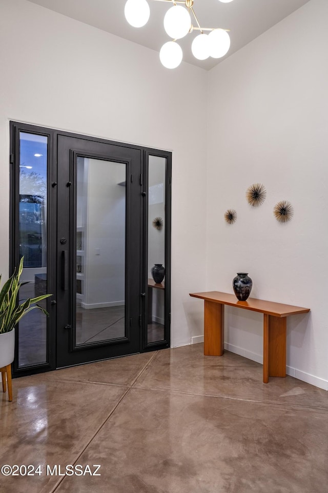 foyer with concrete floors and a chandelier