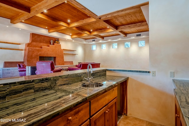 kitchen featuring beamed ceiling, sink, and coffered ceiling