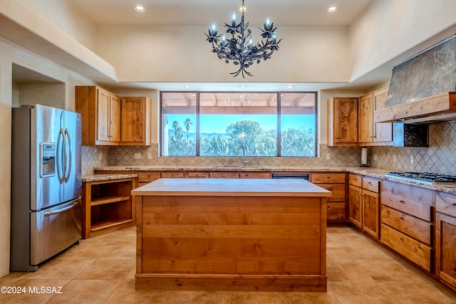 kitchen with decorative backsplash, a kitchen island, appliances with stainless steel finishes, and a chandelier