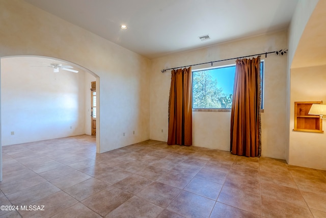 tiled empty room with ceiling fan