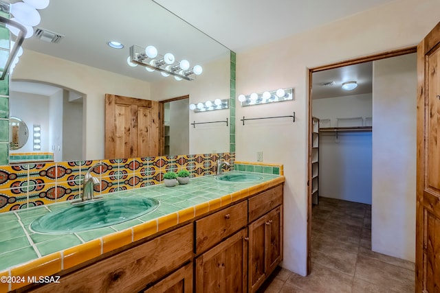 bathroom with tasteful backsplash, tile patterned floors, and vanity