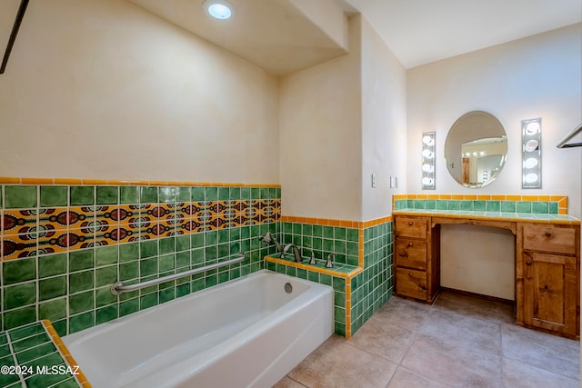 bathroom featuring tile patterned flooring, a washtub, tile walls, and vanity