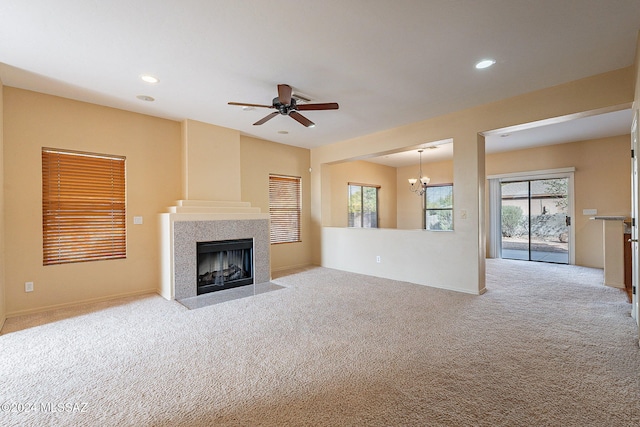 unfurnished living room with light carpet and ceiling fan with notable chandelier