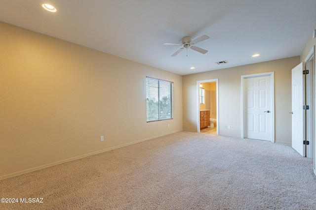 unfurnished bedroom with light colored carpet, connected bathroom, and ceiling fan