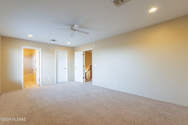 unfurnished bedroom with connected bathroom, ceiling fan, and light carpet